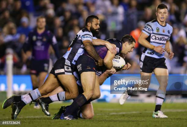 Billy Slater of the Storm is tackled during the round 14 NRL match between the Cronulla Sharks and the Melbourne Storm at Southern Cross Group...