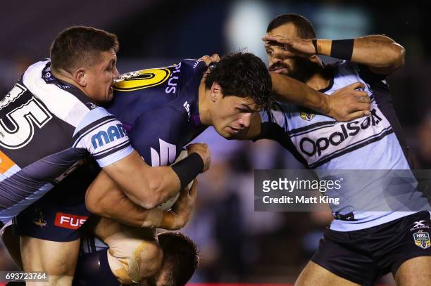 Jordan McLean of the Storm is tackled during the round 14 NRL match between the Cronulla Sharks and the Melbourne Storm at Southern Cross Group...
