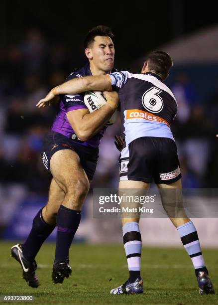 Nelson Asofa-Solomona of the Storm is tackled during the round 14 NRL match between the Cronulla Sharks and the Melbourne Storm at Southern Cross...