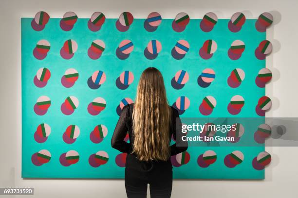 Gallery assistant views 'Giant', oil on shaped canvas, 1950 by Derek Boshier as part of the Modern & Post War British Art exhibition at Sotheby's...