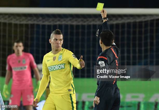 Referee Mario Herrera shows a yellow card to Matheus Uribe of Atletico Nacional during the Semi Finals first leg match between Millonarios and...