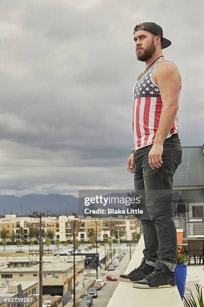 man standing on rooftop ledge - unfilteredtrend stock pictures, royalty-free photos & images