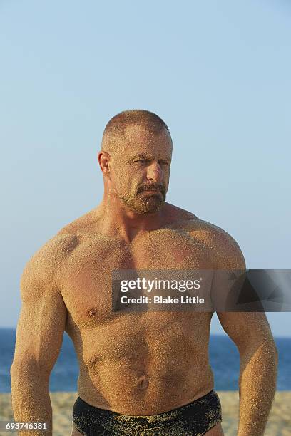 muscle man on beach closeup w sand - muscle men at beach stock pictures, royalty-free photos & images
