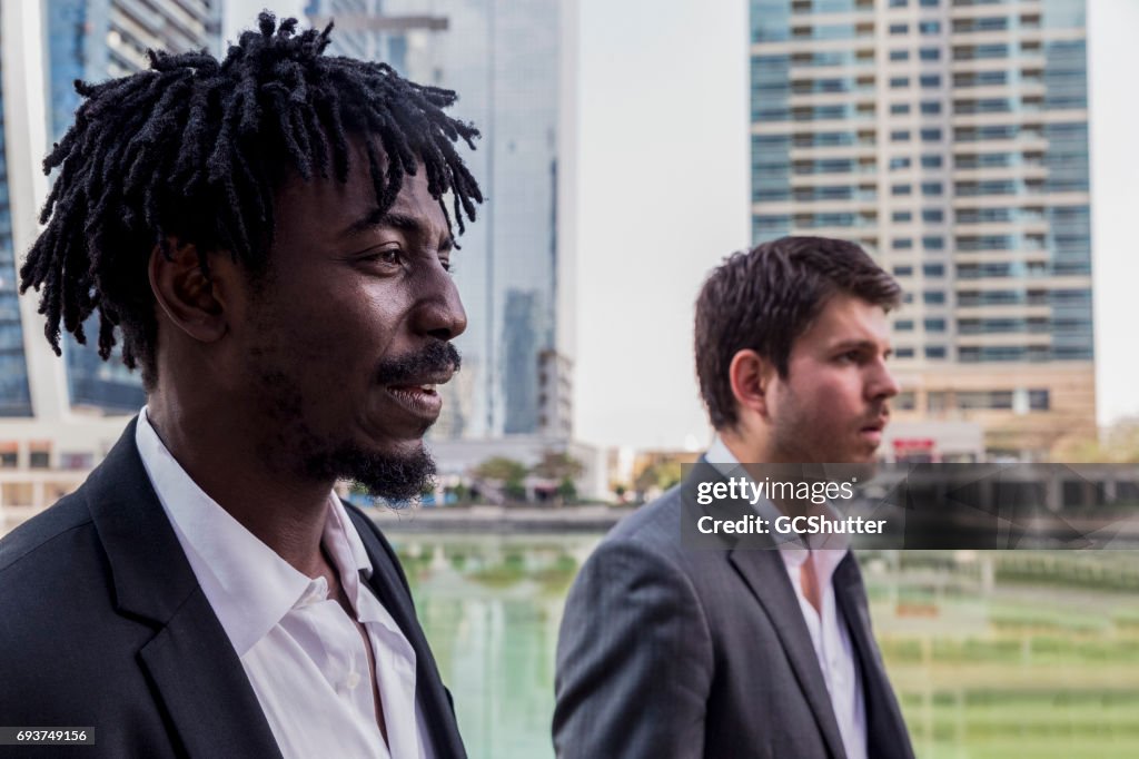 Businessmen walking side by side at the marina to work