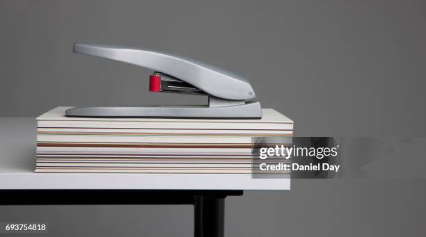 stapler with book on office desk - staples office stockfoto's en -beelden