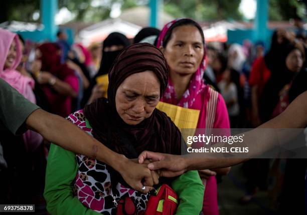 Evacuees queue for relief goods distributed at an covered basketball court used as an evacuation centre in Balo-i, Iligan, on the southern Philippine...