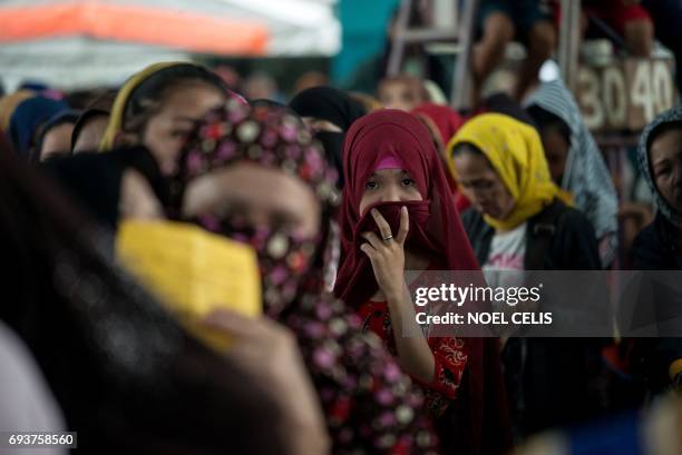 Evacuees queue for relief goods distributed at an covered basketball court used as an evacuation centre in Balo-i, Iligan, on the southern Philippine...