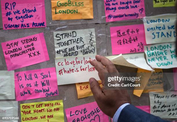 Man places a message next to other notes on a plinth on London Bridge following Saturday's terror attack, on June 8, 2017 in London, England. Eight...