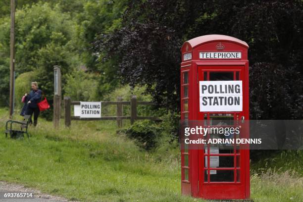 Polling station sign is seen on a telephone box outside the polling station at Rotherwick Hall, west of London, on June 8 as Britain holds a general...