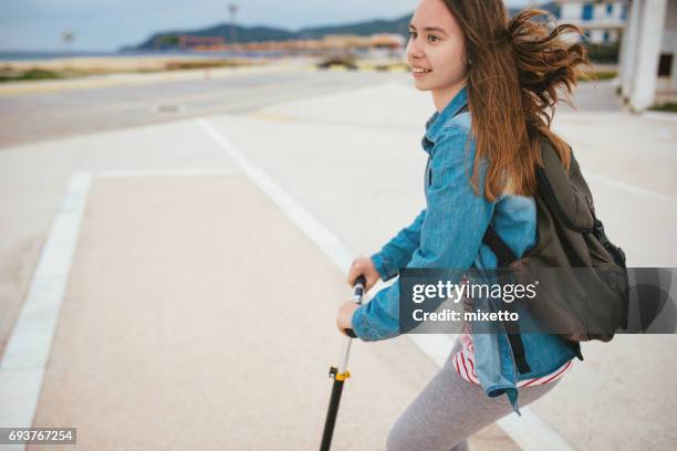 teenager-mädchen auf einem roller - roller fahren stock-fotos und bilder