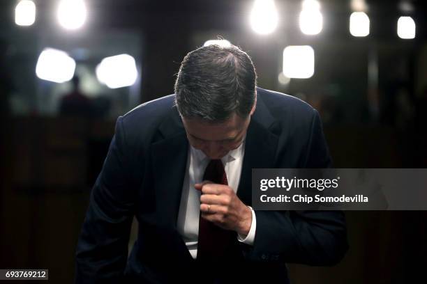 Former FBI Director James Comey takes his seat after being sworn in before the Senate Intelligence Committee in the Hart Senate Office Building on...