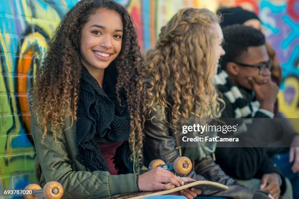 smiling with her skateboard - mural portrait stock pictures, royalty-free photos & images