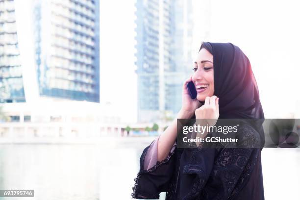 moderne arabische vrouw praten over haar slimme telefoon - people from oman stockfoto's en -beelden