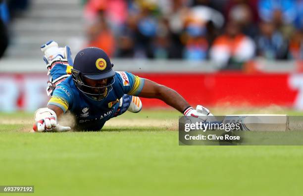Kusal Perera of Sri Lanka dives to make his ground and injures himself in the process during the ICC Champions trophy cricket match between India and...