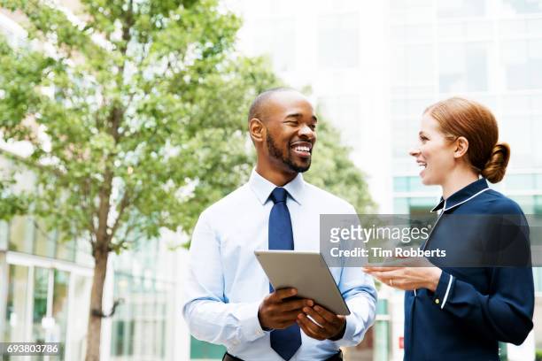 two people with tablet in financial district - vestimenta de negocios formal fotografías e imágenes de stock