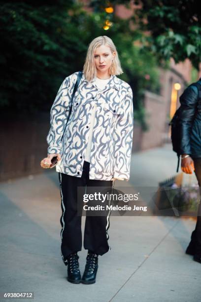 Guest wears a white denim print jacket outside the Stella McCartney Spring 18 presentation on June 8, 2017 in New York City.