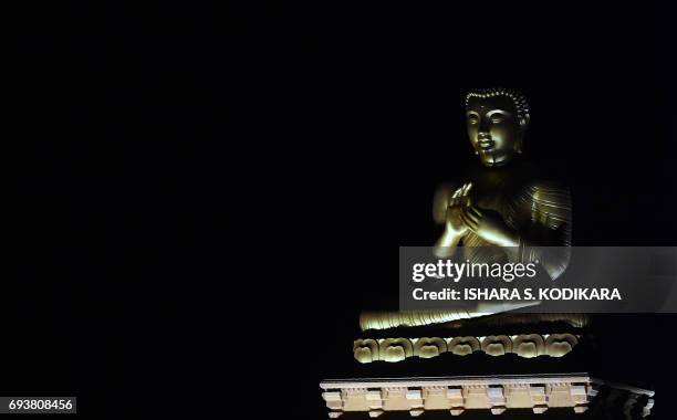 Statue of Buddha is diplayed in a temple in the Colombo suburb of Kelaniya on June 8 during the Poson Festival marking the introduction of Buddhism...