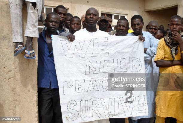 Nigerian IDPs hold a placard reading "we need peace to survive" during the visit of the Nigerian Vice President Yemi Osinbajo to the Bakassi IDPs...