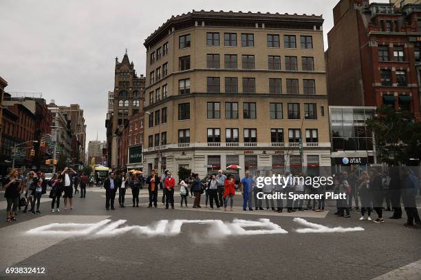 People stand around blocks of dry ice that are positioned to spell out TRUMP as part of an art installation in Union Square by Artist David Datuna on...