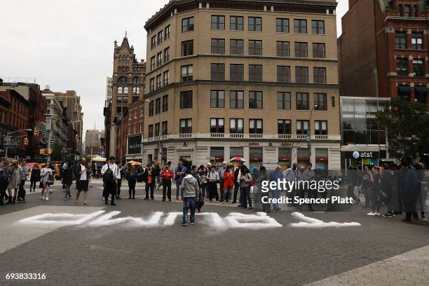People stand around blocks of dry ice that are positioned to spell out TRUMP as part of an art installation in Union Square by Artist David Datuna on...