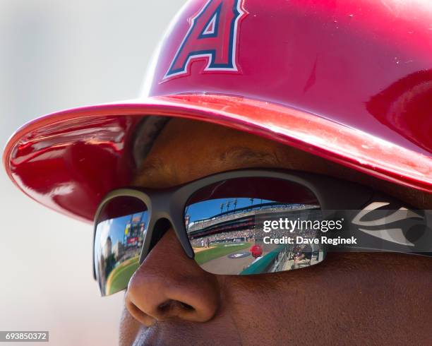 Alfredo Griffin of the Los Angeles Angels of Anaheim watches the action from the dugout in the sixth inning during a MLB game against the Detroit...