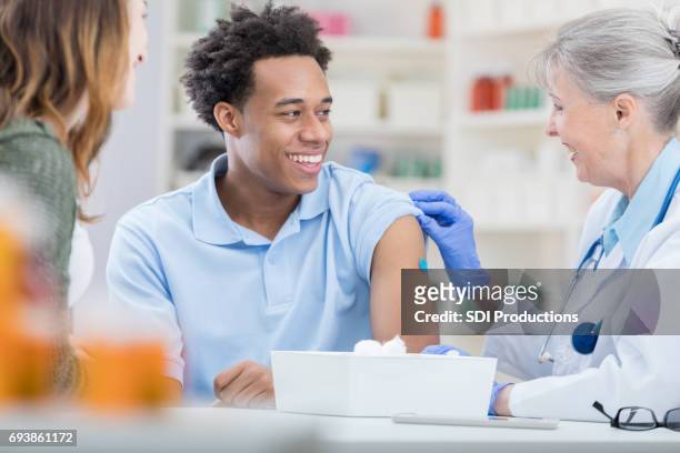 african american receives flu vaccine - influenza virus stock pictures, royalty-free photos & images