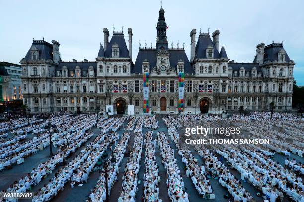Participants dressed in white participate in a "Diner en Blanc" in front of the City Hall in Paris on June 8, 2017. The 29th Edition of the "Diner en...