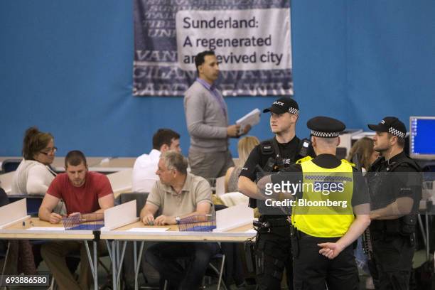 Armed police stand guard as volunteers count ballot papers for three constituencies in Tyne and Wear ceremonial county at the Silksworth Community...