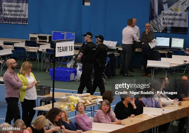 Armed police patrol the hall during the General Election Parliamentary counts at Silksworth Community Centre in Sunderland.