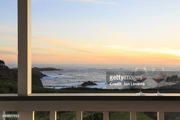 wine on deck overlooking ocean and sunset - メンドシノ ストックフォトと画像