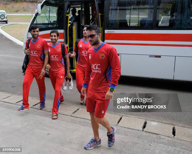 Usman Ghani and Karim Janat of Afghanistan disembark their bus to take part in a training session at Darren Sammy National Cricket Stadium on June...