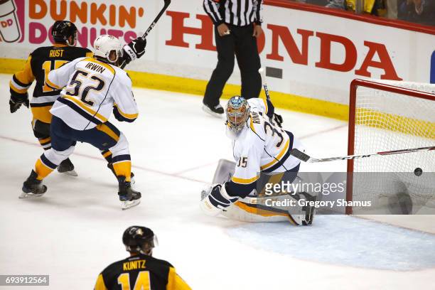 Bryan Rust of the Pittsburgh Penguins scores his team's second goal in the first period against Matt Irwin and goalie Pekka Rinne of the Nashville...