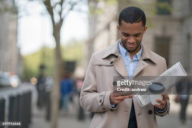 business man texting on his mobile phone outdoors - man atm smile stock pictures, royalty-free photos & images