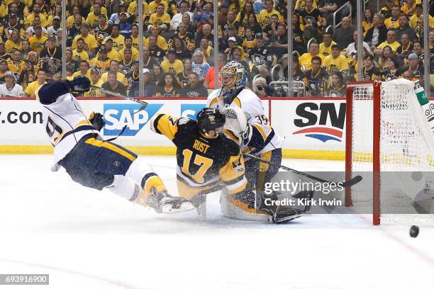 Bryan Rust of the Pittsburgh Penguins collides with Pekka Rinne and Roman Josi of the Nashville Predators in the first period in Game Five of the...