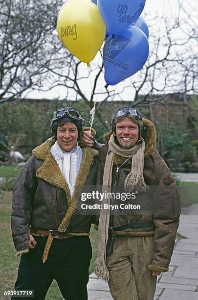Richard Branson, co-founder of Virgin Atlantic Airways, right, poses in a leather flying jacket and helmet with his fellow co-founder of Virgin...