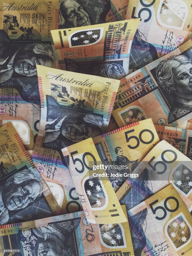 Australian fifty dollar notes scattered in a large pile