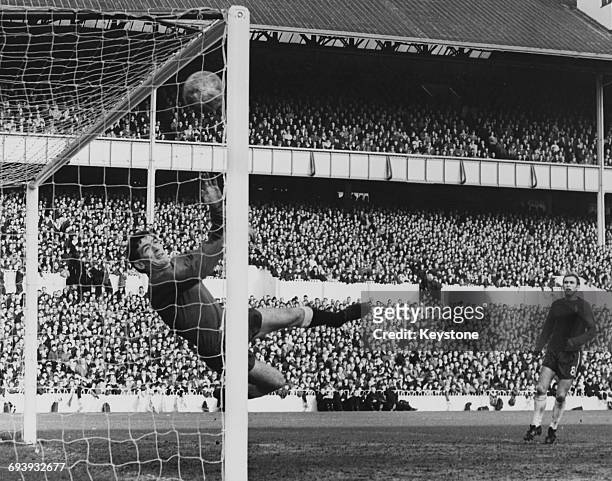Goalkeeper Pat Jennings of Spurs dives in vain to save the goal from 16 year old Chelsea midfielder Chico Hamilton as Tommy Baldwin number 8 looks on...