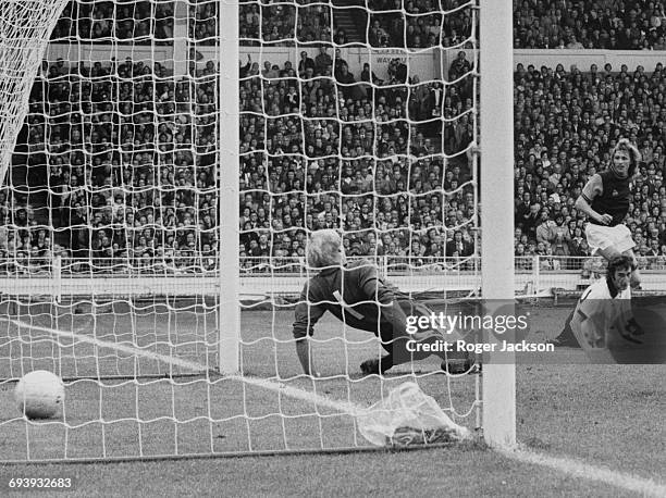 Alan Taylor of West Ham United shoots the ball between the legs and into the net of Fulham goalkeeper Peter Mellor to score as Fulham defender John...