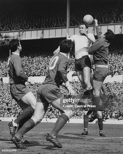 Goalkeeper Tommy Lawrence of Liverpool attempts to punch the ball clear from Spurs forward Alan Gilzean as number 10 Tommy Smith and number 5 Ron...