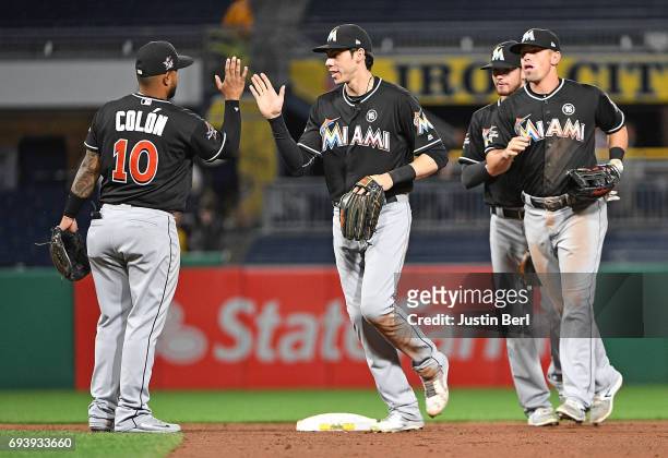 Christian Colon of the Miami Marlins celebrates with Christian Yelich after the final out in the Miami Marlins 7-1 win over the Pittsburgh Pirates at...