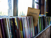 History on book cover on bookshelf, education concept