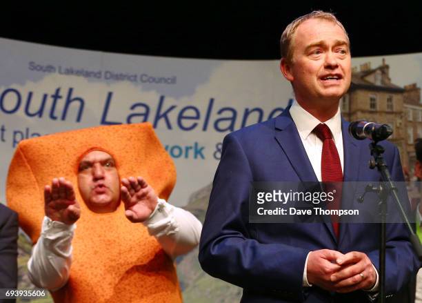 Leader of the Liberal democrats Tim Farron stands in front of Independent candidate Mr Fishfinger following the announcement of the results and that...