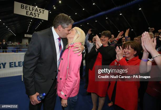 Leader Arlene Foster cheers as Gavin Robinson kisses his wife Lindsey after he is elected to the East Belfast constituency at the Titanic exhibition...