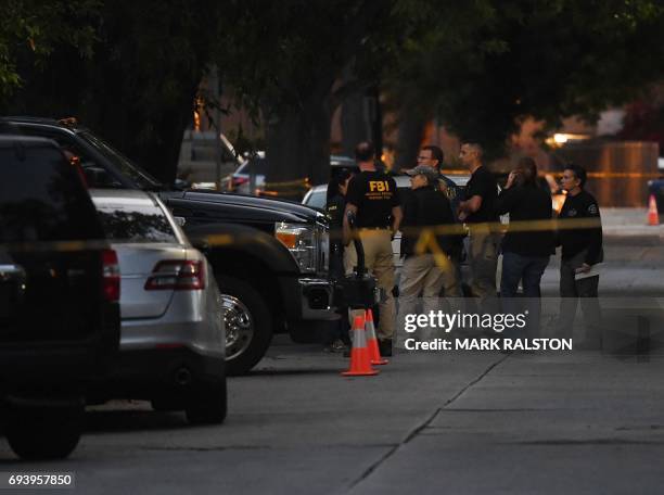 Agents assemble outside a house where federal investigators and local police held a raid and detained three people in the mid-city area of Los...