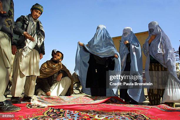 Afghanistan women in burqas shop for carpets January 22, 2002 in downtown Kabul, Afghanistan. As more people come back to the capital city citizens...