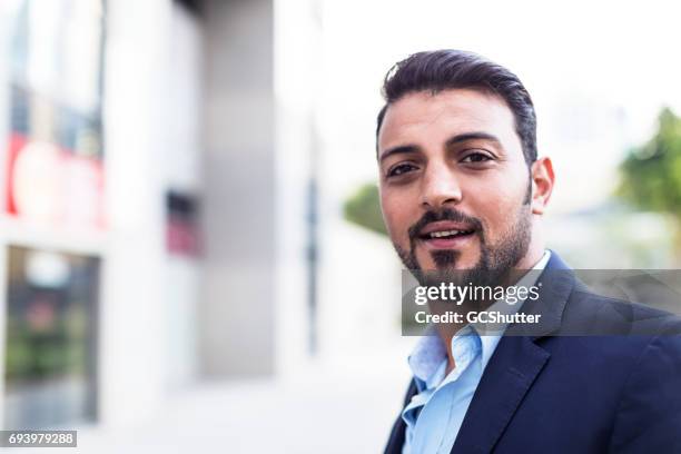 confident arab businessman smiling at the camera - bahrain man stock pictures, royalty-free photos & images