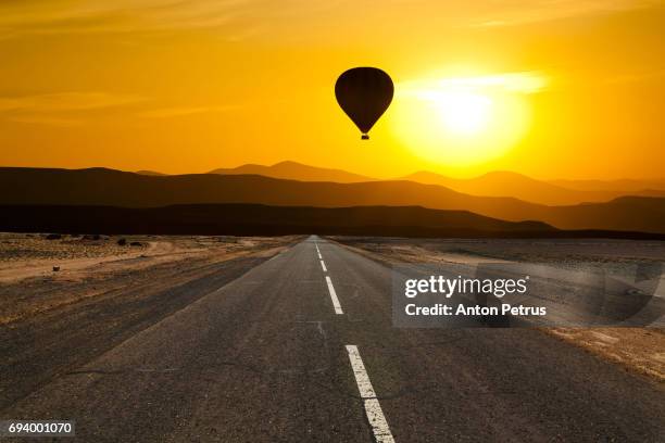 hot air balloon over the scenic desert road - africa road stock pictures, royalty-free photos & images