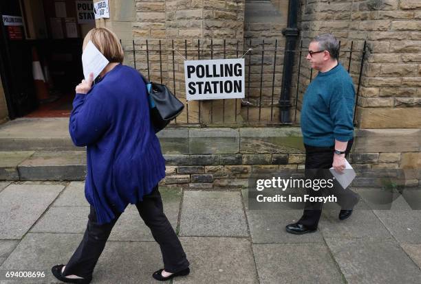 Woman hides her face with her polling card outside a polling station on June 8, 2017 in Saltburn-by-the-Sea, United Kingdom. Polling stations open...