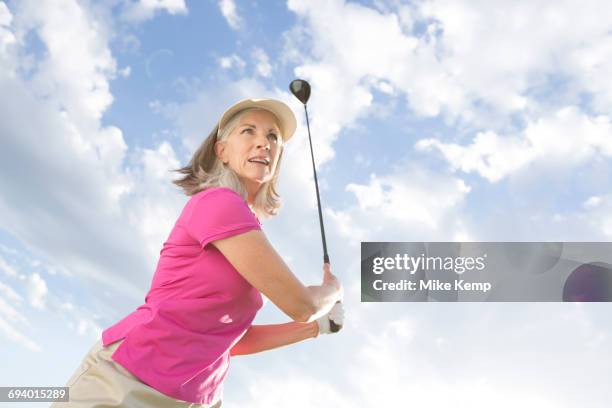 caucasian woman swinging golf club - woman on swing foto e immagini stock