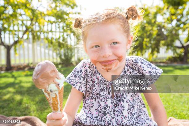 caucasian girl with messy face eating ice cream cone - girl eating messy ice cream cone stock-fotos und bilder